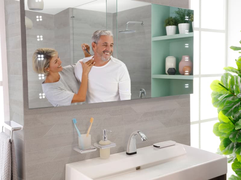 Baño iluminado y chic con espejo moderno y accesorios